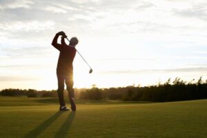 senior-man-golfing-sunset-swing
