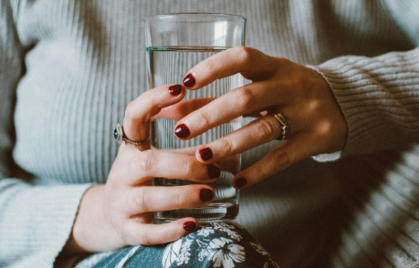 woman's hands holding water glass