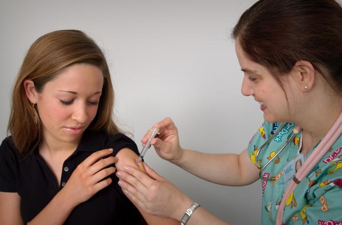 Nurse delivers covid vaccine to woman patient's arm