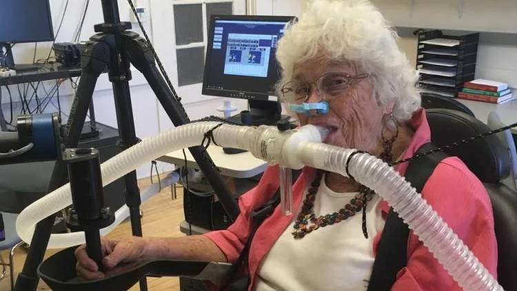 Mary Kaupas participates in a experiment to study how humans of various ages reach for targets. Tubes monitor her breathing to measure how much energy she uses. (Credit: Erik Summerside/Mary Kaupas)