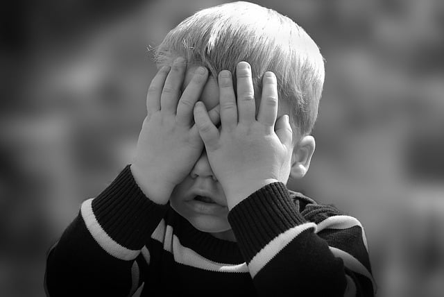 young boy covering his eyes