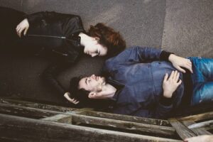 man and woman lying on ground outside