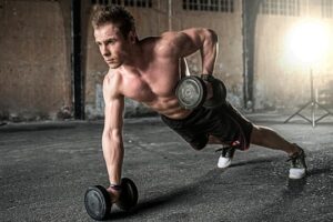 Man exercising at night, doing weighted pushups