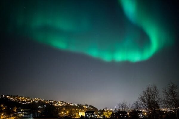 Solar wind causing an aurora over a town at night