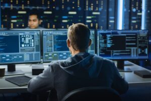 guy who looks like a hacker sitting at a computer