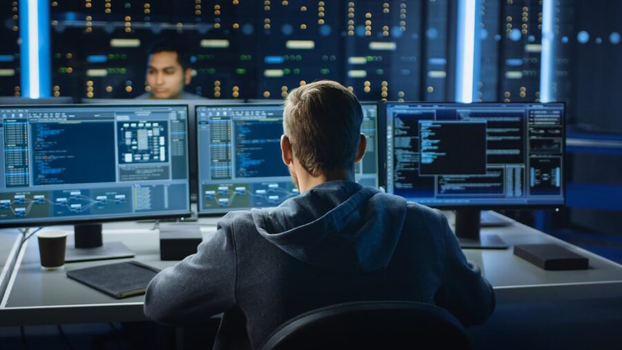 guy who looks like a hacker sitting at a computer