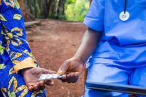 physician handing pills to patient