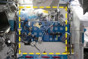 A sample location from the Sampling Quadrangle Assemblages Research Experiment (SQuARE), Square 03 in the starboard Maintenance Work Area of the International Space Station. An open crew berth is visible at right. The yellow dotted line indicates the boundaries of the sample area. Credit: NASA/ISSAP.