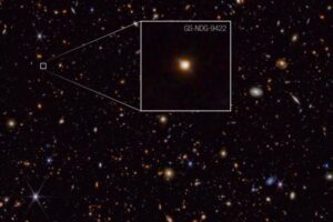 This image of galaxy GS-NDG-9422, captured by the James Webb Space Telescope's NIRCam (Near-Infrared Camera) instrument, is presented with compass arrows, scale bar, and colour key for reference.