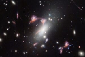 The galaxy cluster MACS-J0417.5-1154 is so massive that it bends the fabric of space-time. This causes the appearance of galaxies behind it to be distorted, an effect known as gravitational lensing. This natural phenomenon magnifies distant galaxies and can also make them appear in an image multiple times, as NASA's James Webb Space Telescope has observed. In this image, two distant, interacting galaxies - a face-on spiral and a dusty red galaxy seen from the side - appear multiple times, tracing a familiar shape across the sky. The fact that these galaxies are actively forming stars and that the face-on galaxy's spiral shape is remarkably intact indicates that their interaction is just beginning.