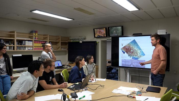 Dr Uisdean Nicholson presenting his findings to scientists on board a drilling ship.