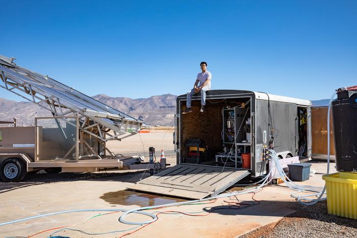 Jon Bessette sits atop a trailer housing the electrodialysis desalination system at the Brackish Groundwater National Research Facility (BGNDRF) in Alamogordo, New Mexico. The system is connected to real groundwater, water tanks, and solar panels.