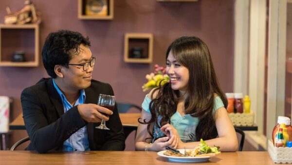 a couple on a date at a restaurant both smiling