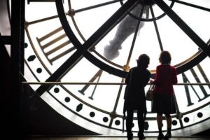 two women behind an enormous clock