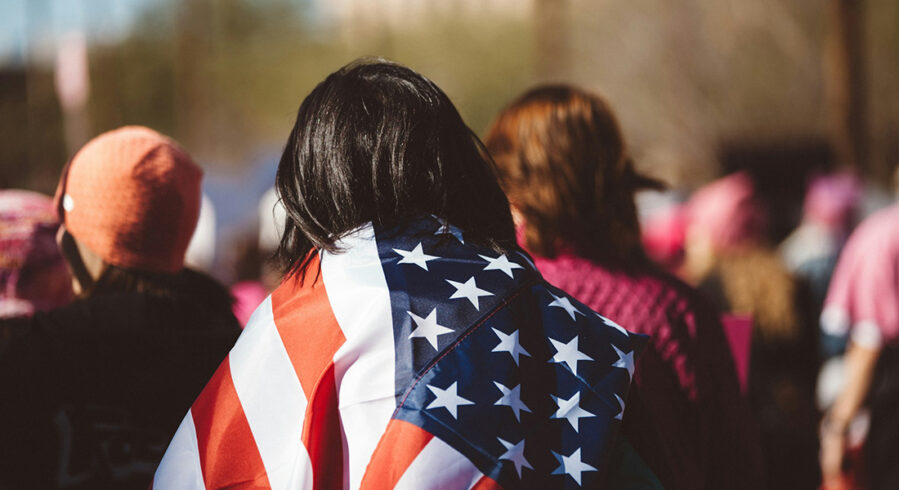 Person seen from behind wrapped in a U.S. flag