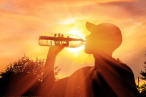 Silhouette of a man drinking water during heat wave