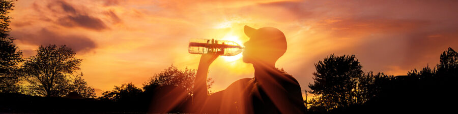 Silhouette of a man drinking water during heat wave