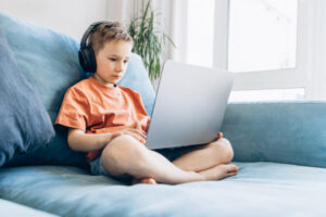 Boy with laptop wearing headphones