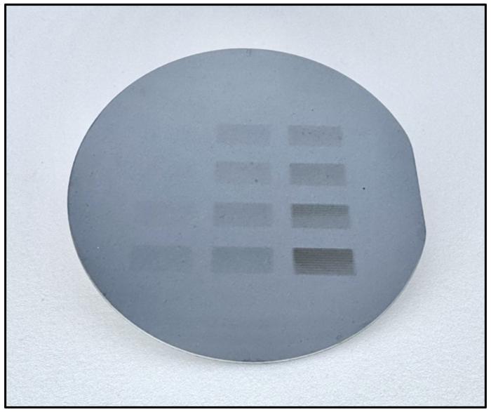A 10 cm silicon wafer with large visible patterns created using B-EUV lithography.