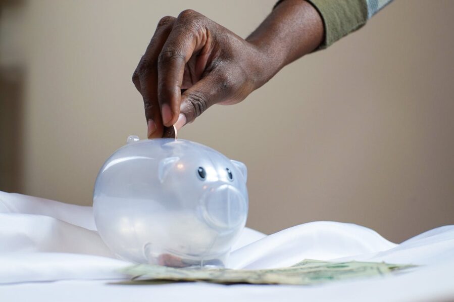 Hand dropping a coin into a piggybank