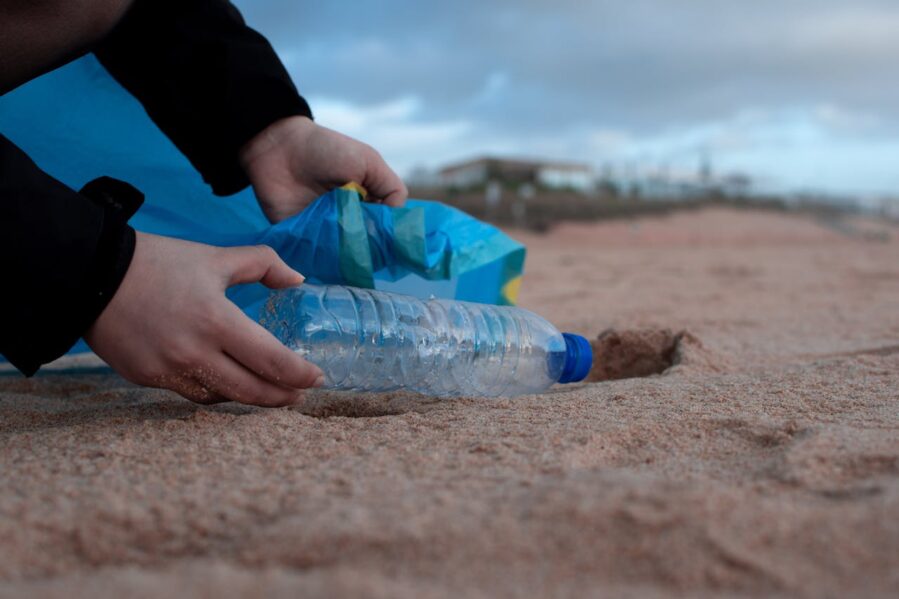 person picking up trash at the beach