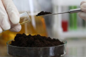 Female chemist in white protective gloves hold test tube against chemistry lab background closeup.