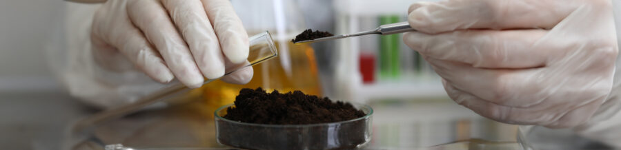 Female chemist in white protective gloves hold test tube against chemistry lab background closeup.