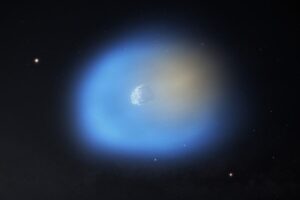 An artist's impression of 3I/ATLAS is shown as it passes near the Sun, illuminating one side of the comet. On the side of the comet closer to the sun, the methanol gas is shown in blue, with icy dust grains still present in the gas. On the dark side of the comet, the hydrogen cyanide is shown in orange. Credit: NSF/AUI/NSF NRAO/M.Weiss