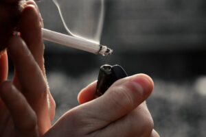 a person addicted to tobacco lighting a cigarette