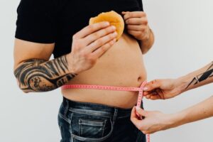 man with hamburger getting his waist measured