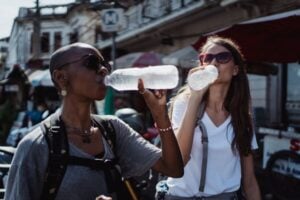 two women drinking water on a hot day