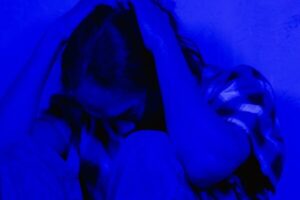 a depressed man sitting on a floor