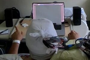 A hearing system monitoring this man’s brain activity amplifies a conversation played on his left while quieting one on his right, based on which conversation his brainwaves suggest he is paying attention to.