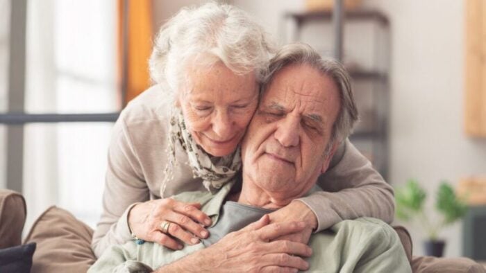 eldery man and woman hugging