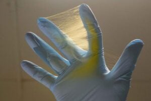 nanofiber mesh between fingers of a gloved hand