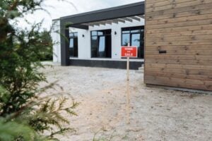 modern home with For Sale sign in front