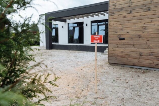 modern home with For Sale sign in front