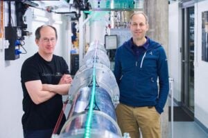 Andreas Wallraff and Renato Renner (f.l.t.r.) next to the 30-meter link connecting two quantum chips. Using this experiment, ETH researchers generated certified perfect randomness for the first time.