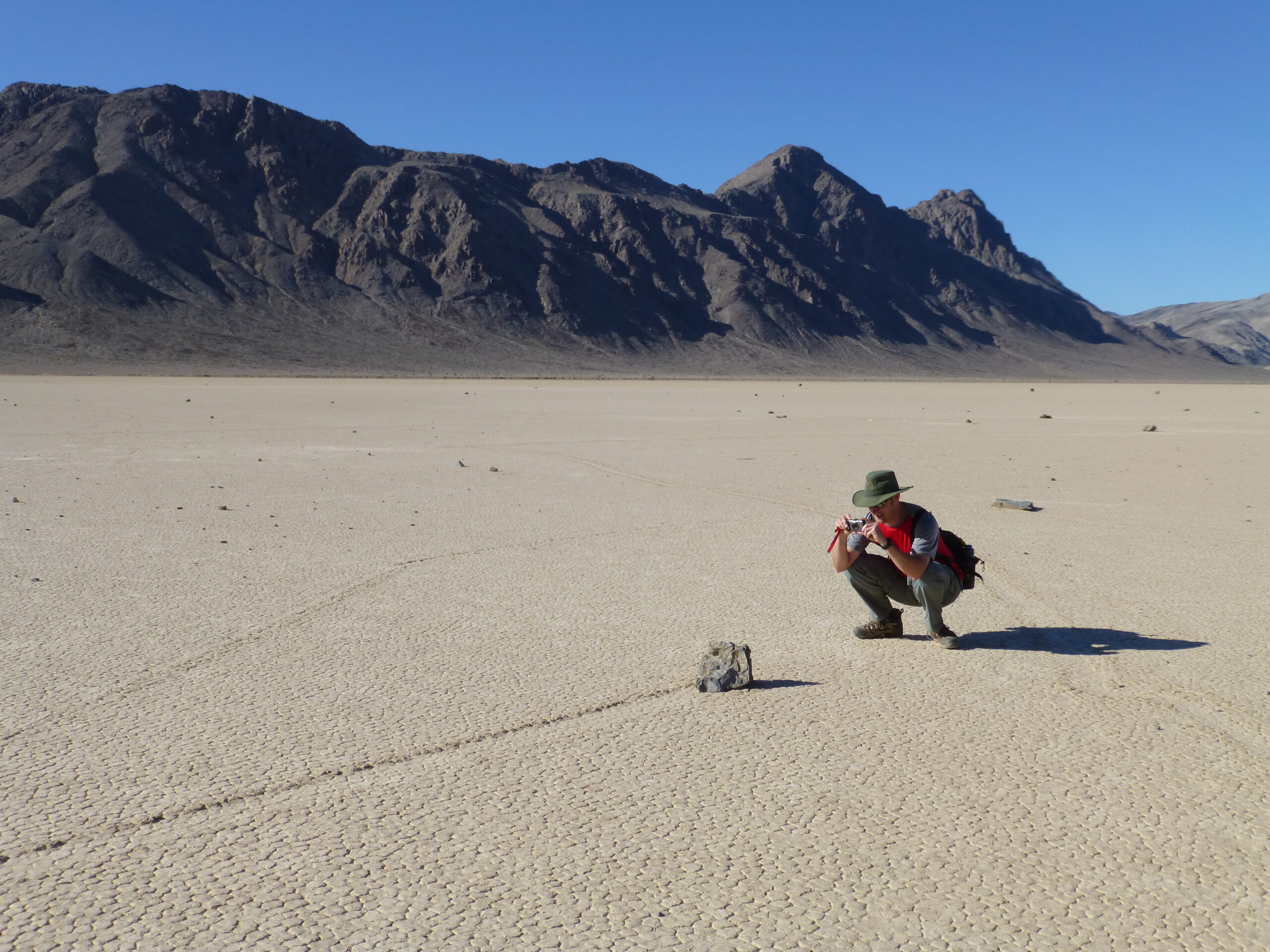 A rock and its long trail across the cracked surface of Racetrack Playa in Death Valley
