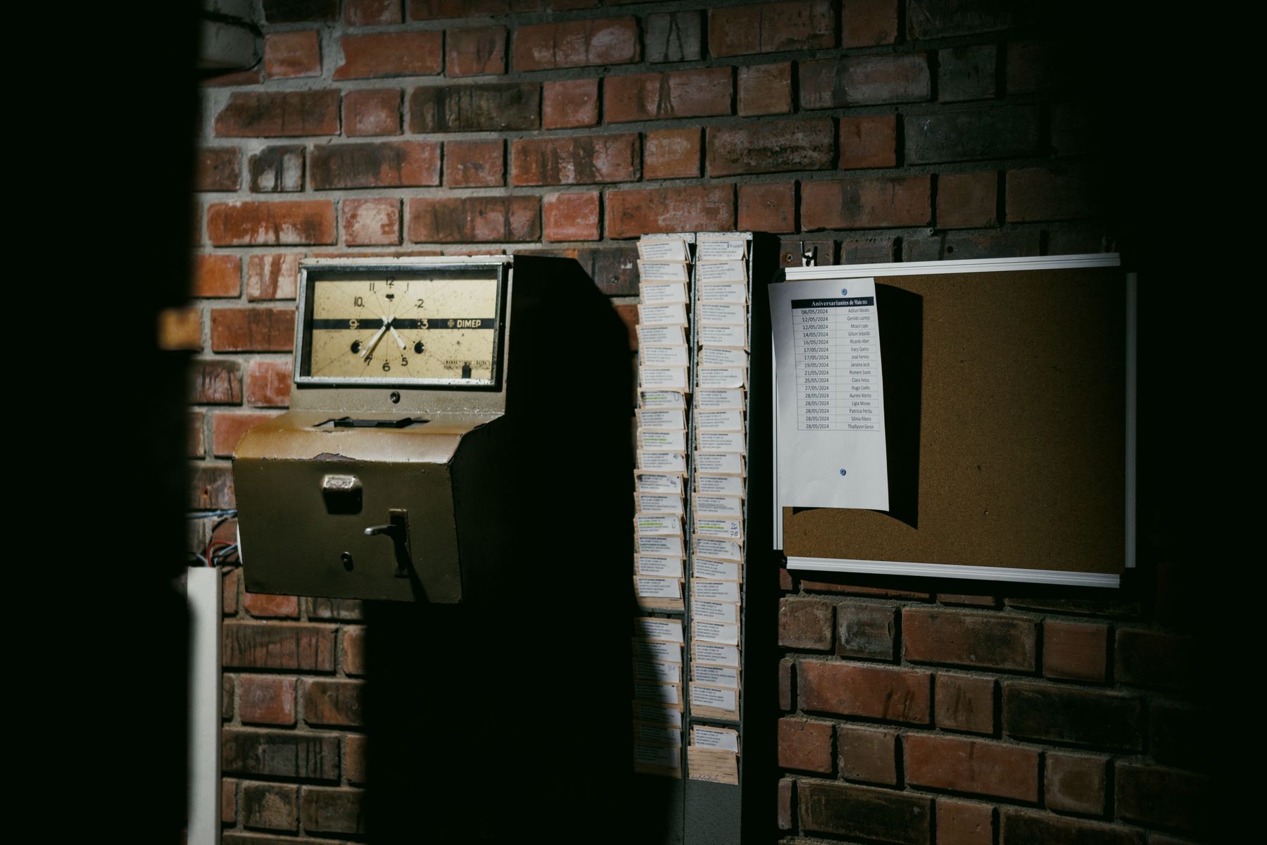 Stack of paper punch cards beside a vintage mechanical time clock