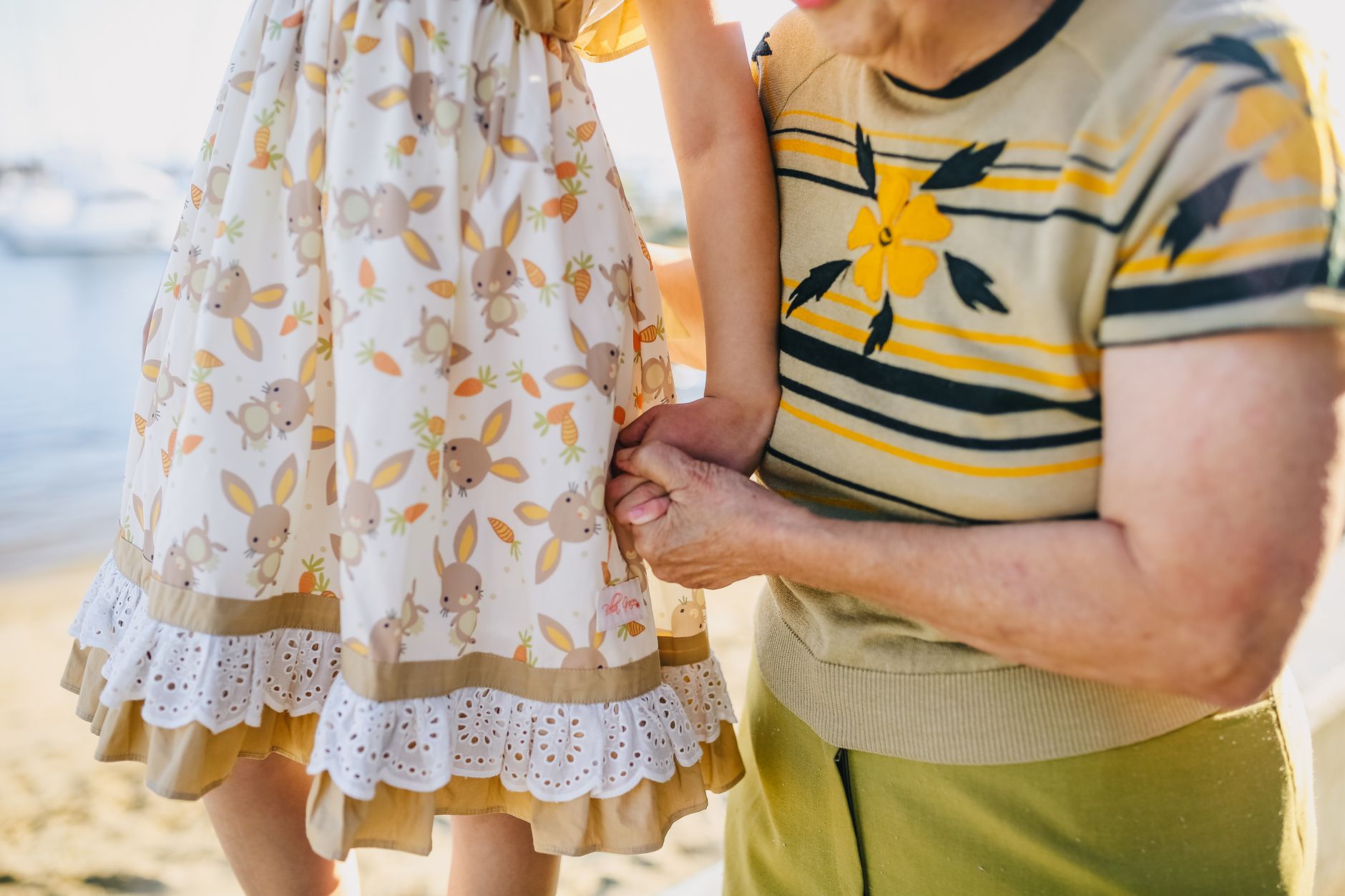 A grandmother and young child walking together holding hands