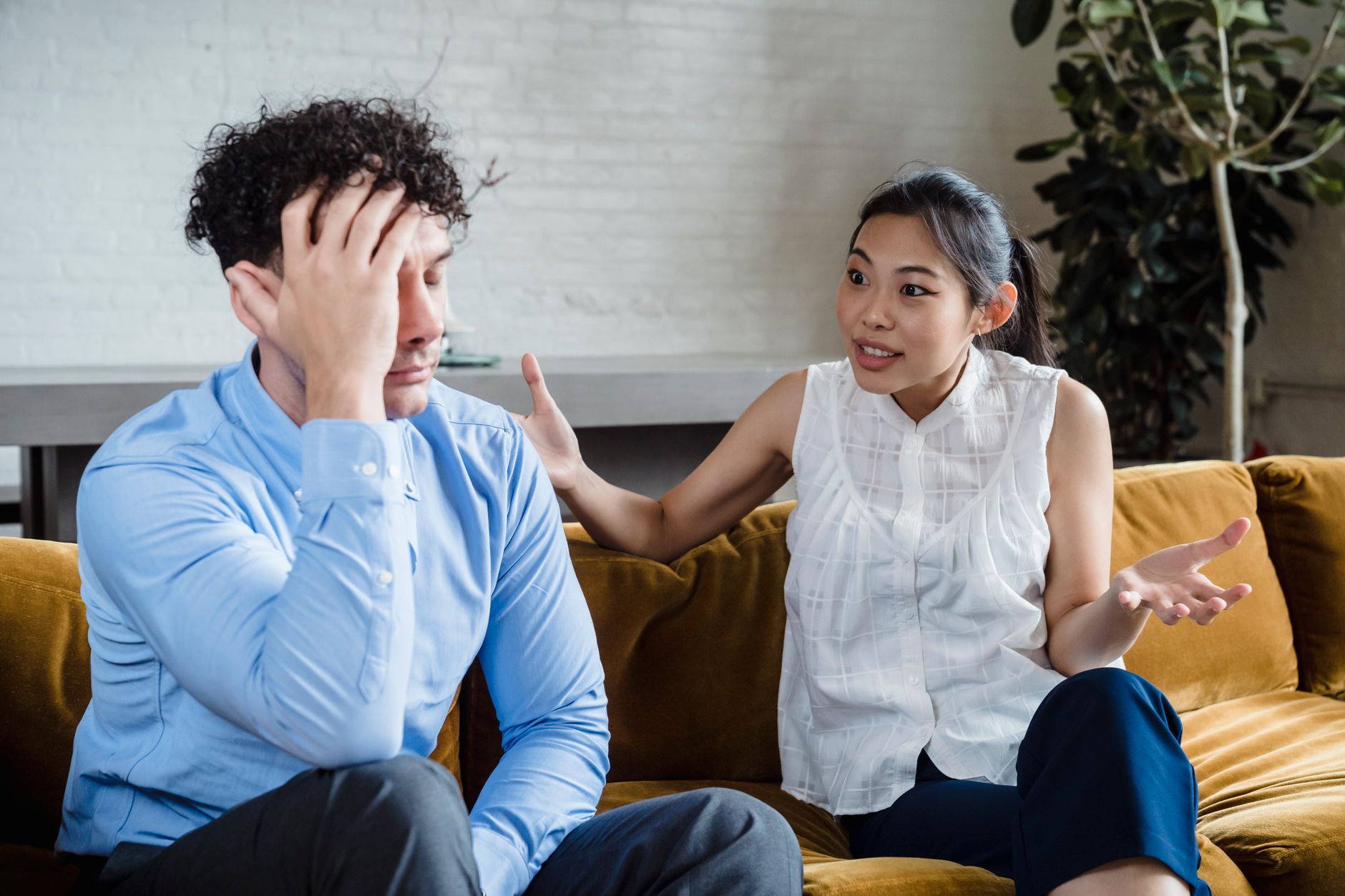 A couple having a serious conversation on a couch.