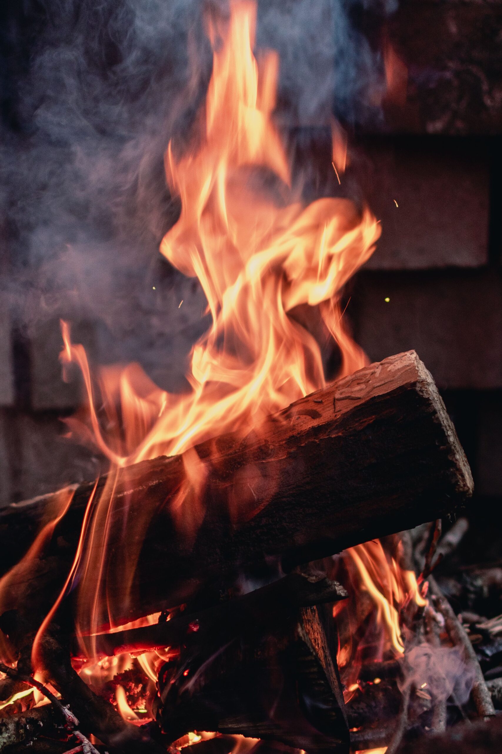 Flames and smoke rising from a wood campfire