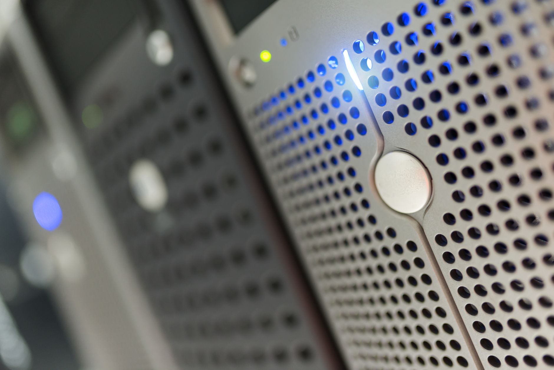 Close-up of a perforated server rack with blue indicator lights