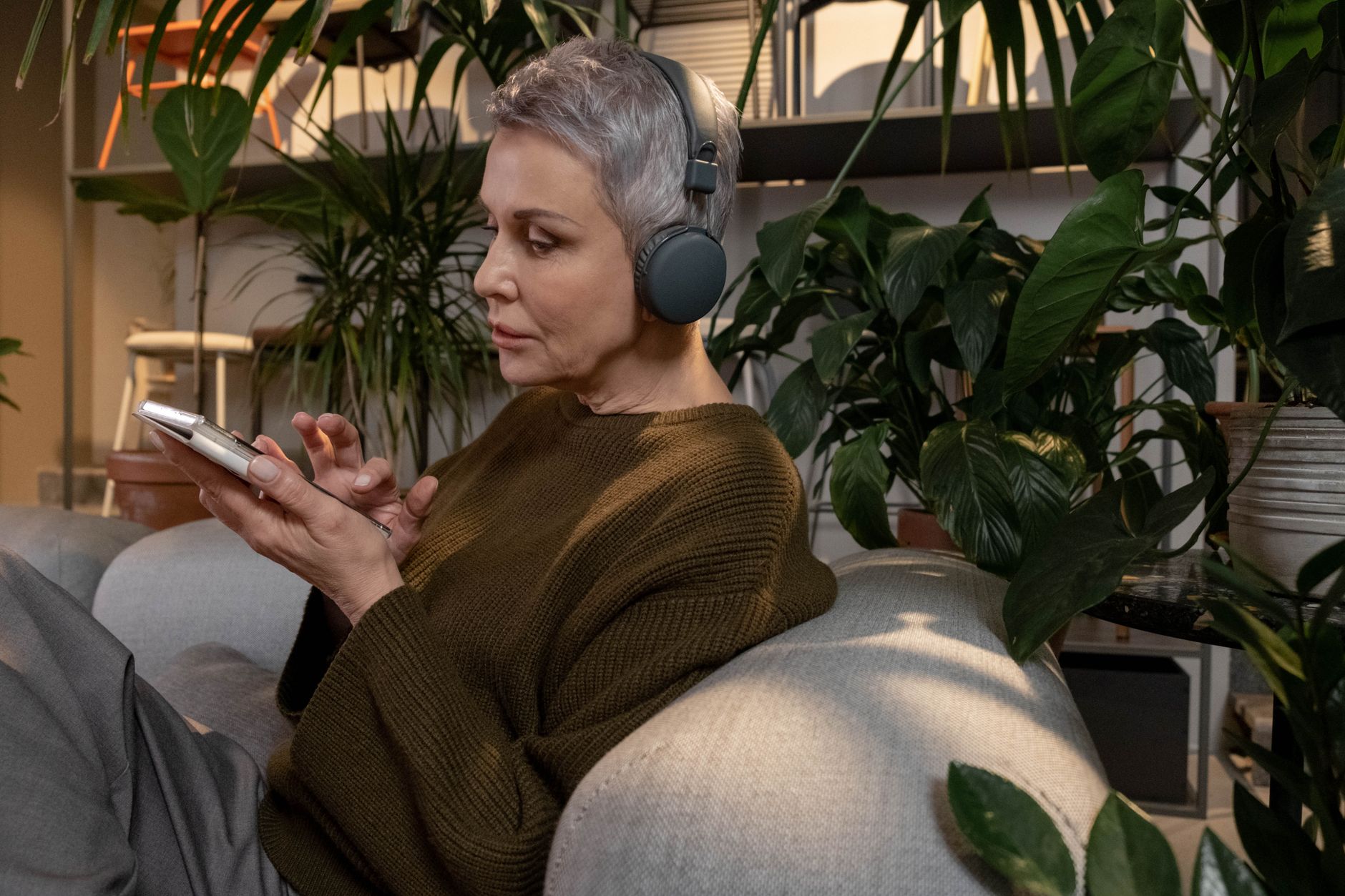 A woman listening to music through headphones while seated at home