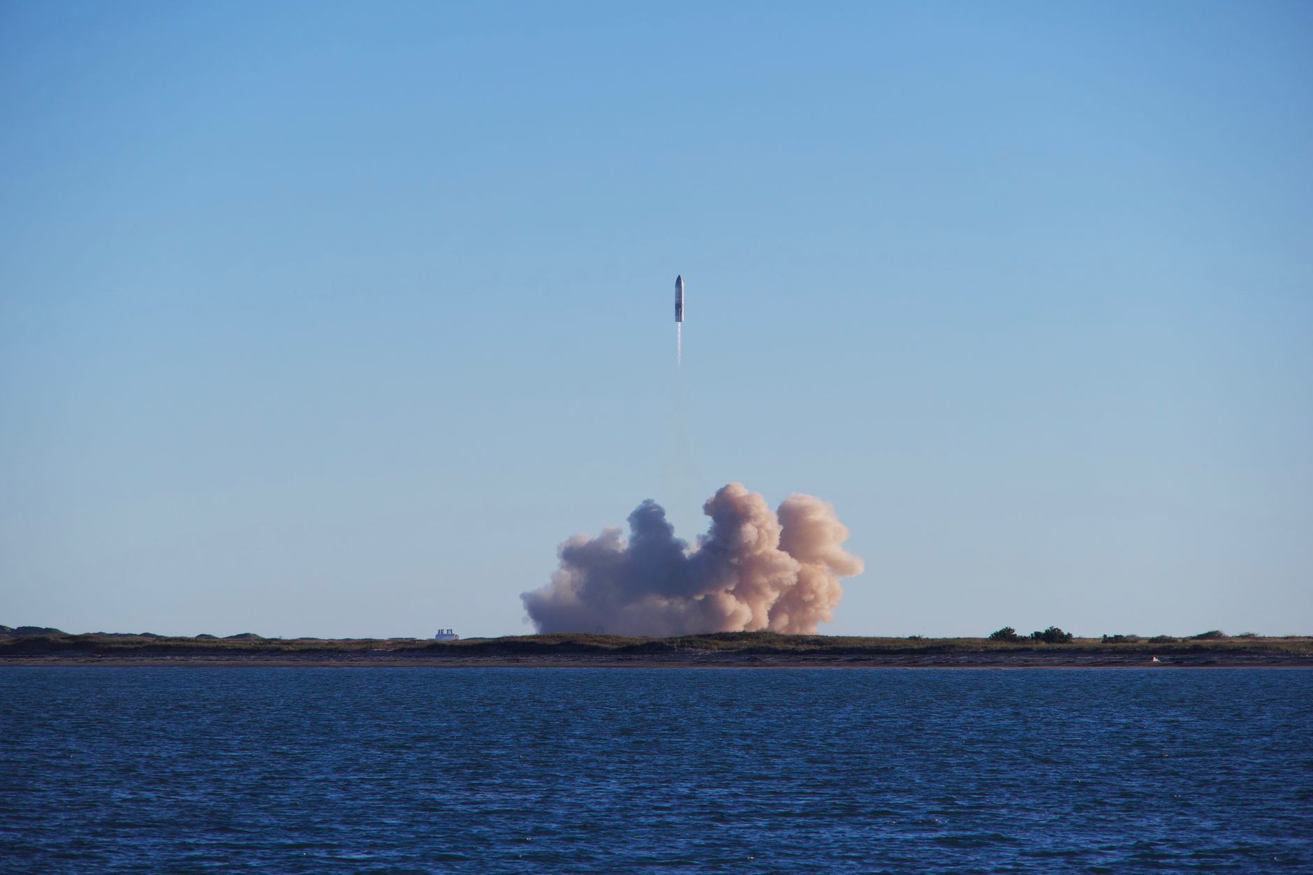 A Starship prototype rising above its launch plume near South Padre Island