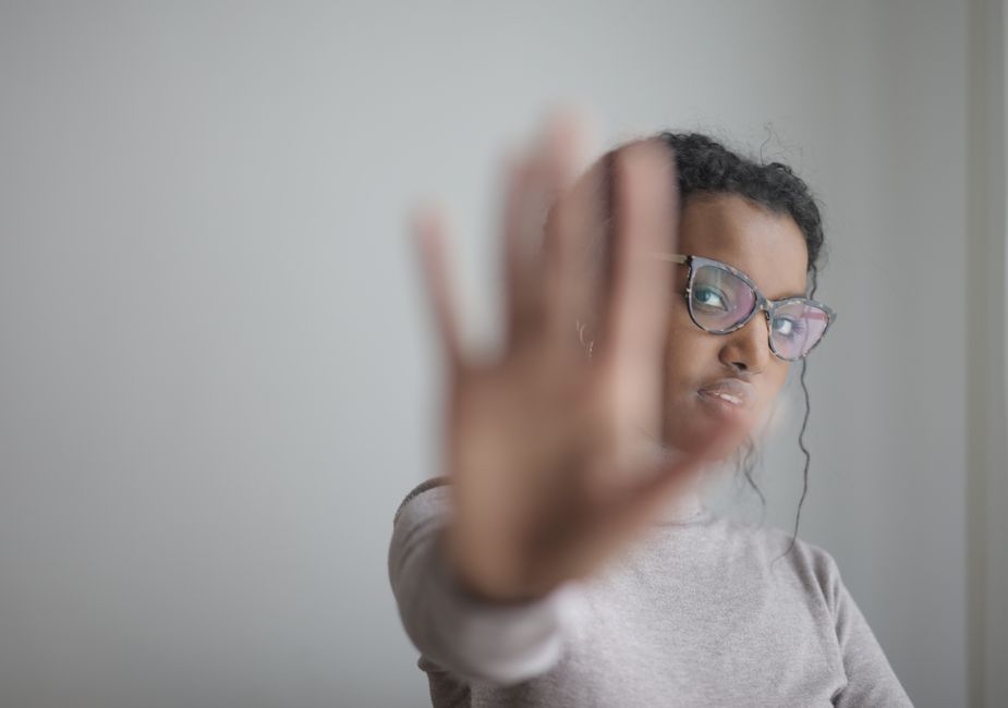 A representative image, not a photograph of any person discussed in the article, showing a woman making a stop gesture with her palm.