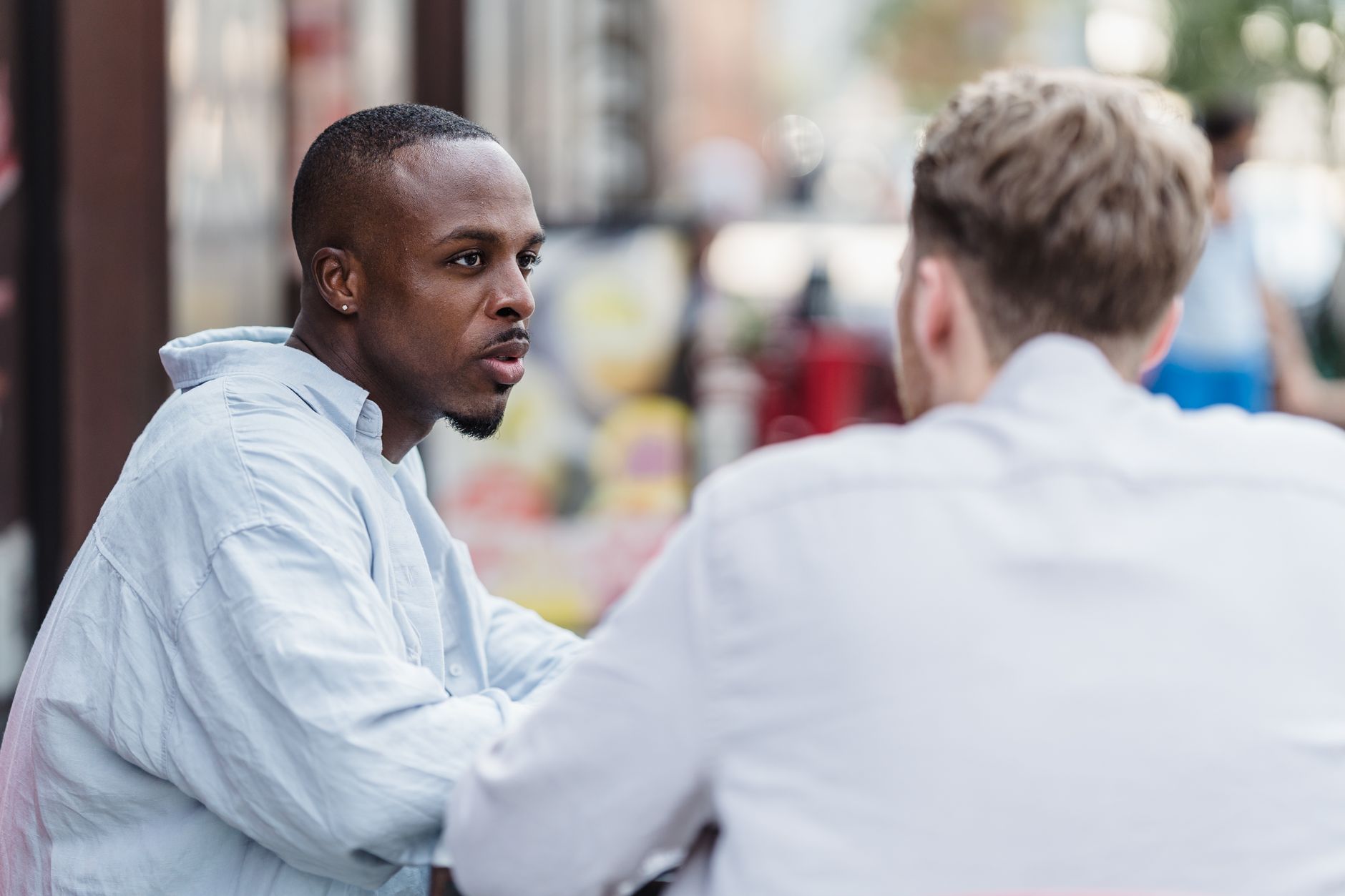 Two people in conversation outdoors.