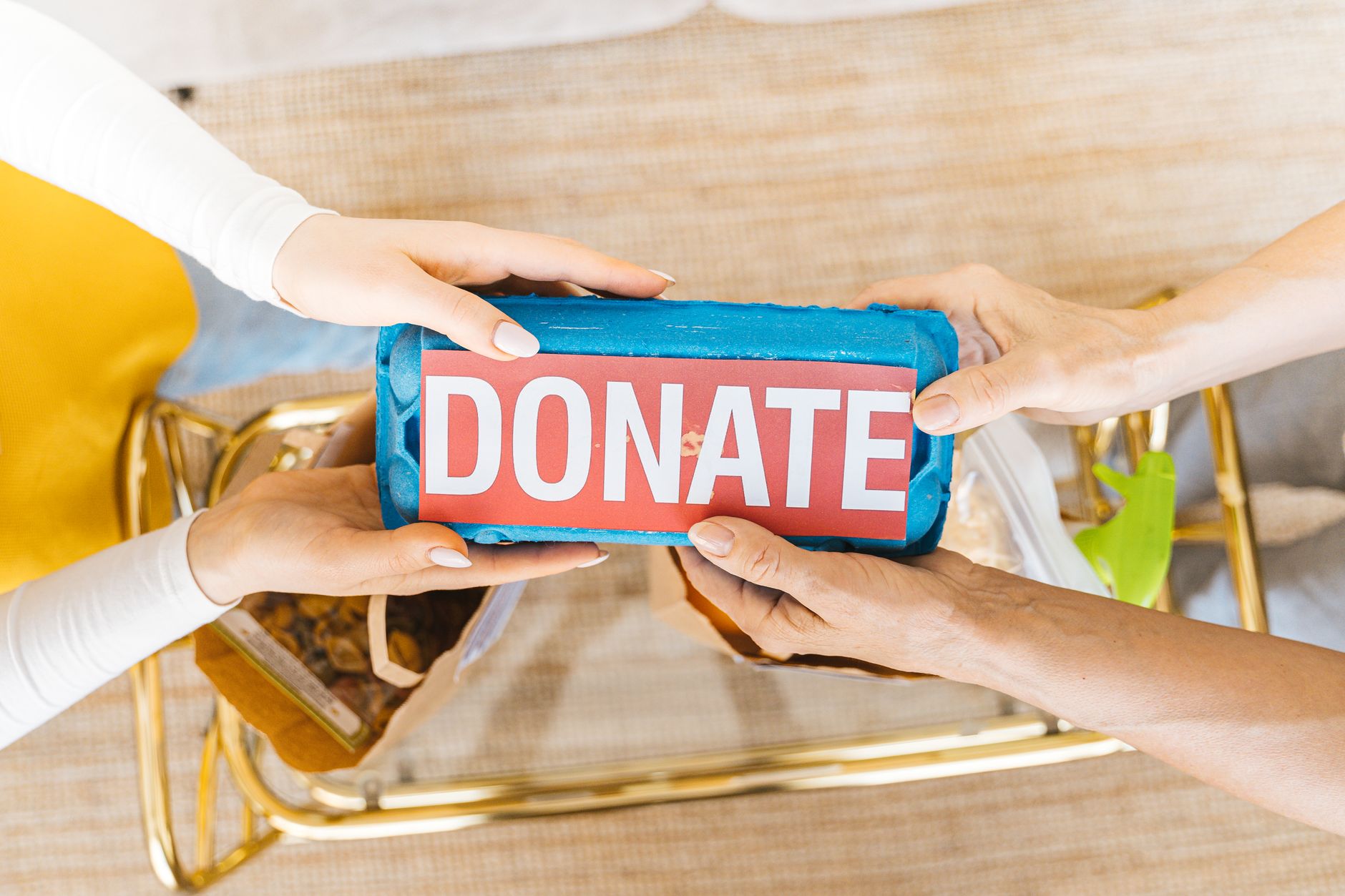 Several hands passing a donation box