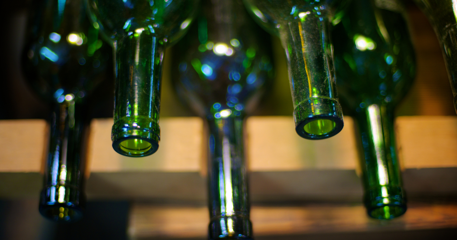 Green glass bottles hanging above a conveyor